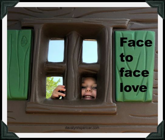 ALT="child looking through playground equipment window"