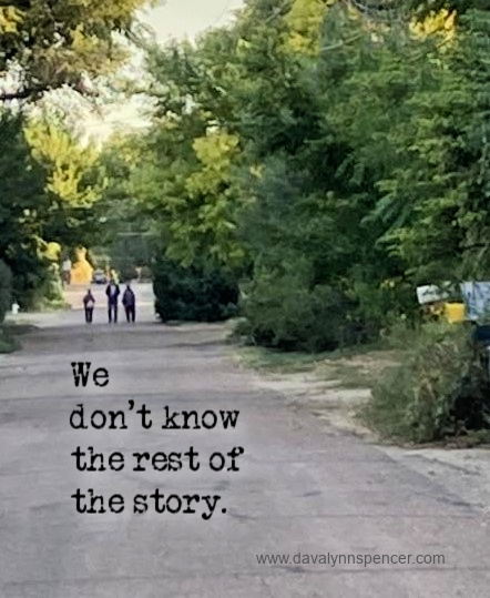 ALT="three people walking along the road"